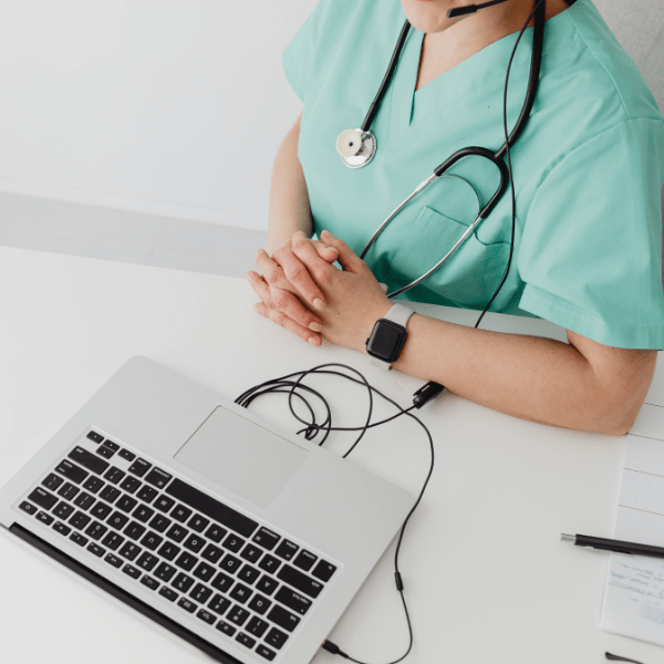 Telehealth clinician on laptop with headset - Acuity Health Solutions